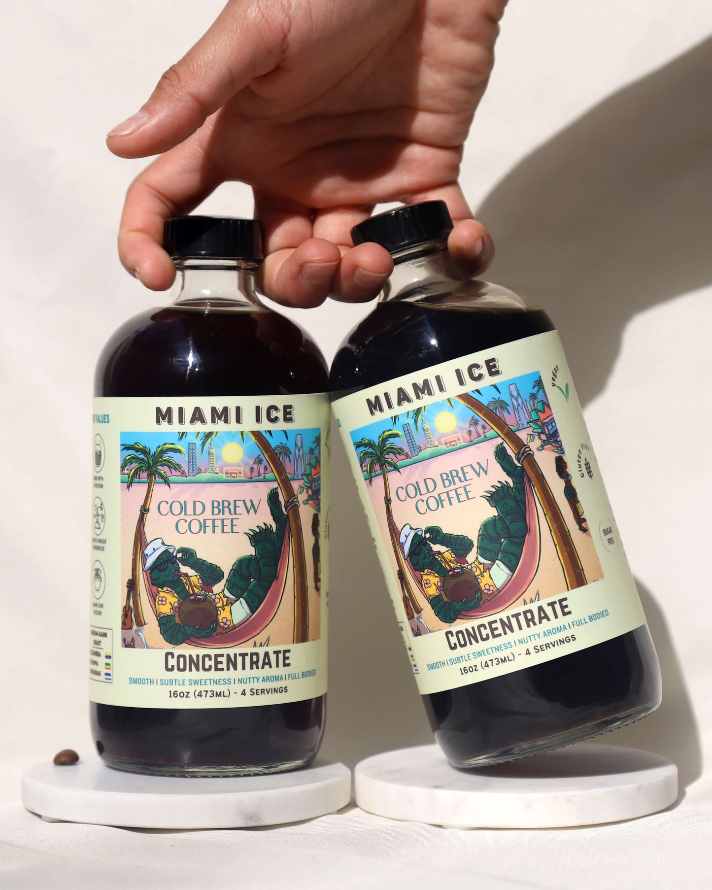 Hand holding 2 bottles of cold brew coffee concentrate